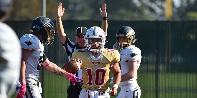 Justin Genovia holds the ball after catching a touchdown pass, as an official signals the touchdown.