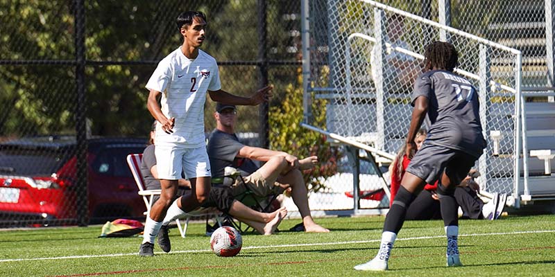 Abdul Ali possesses the ball near the sideline while working against a defender.
