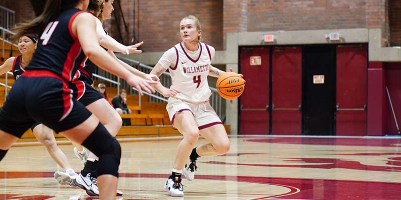 Megan River controls the ball on offense while working against two defenders.